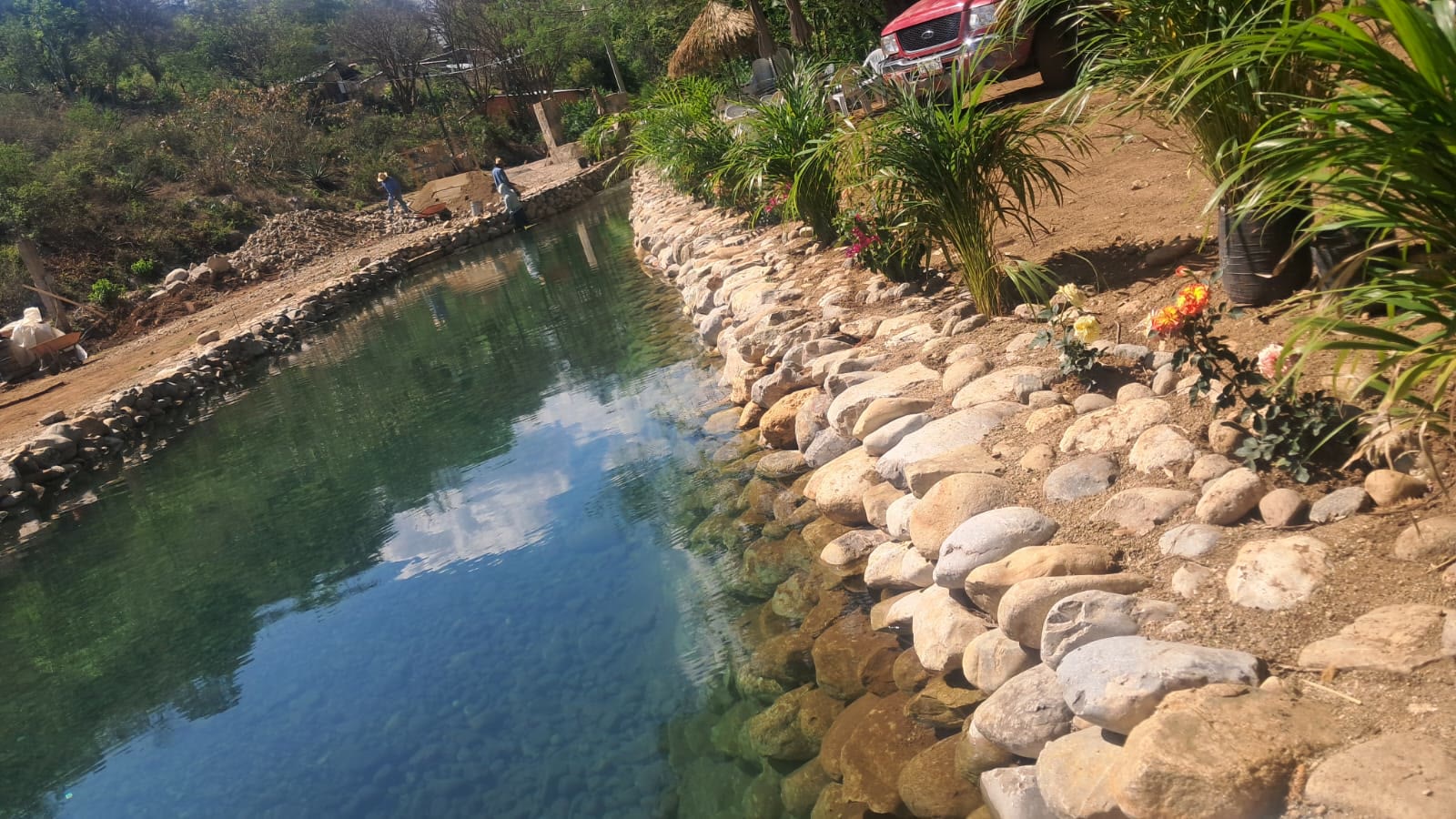 Canal angosto de natación entre muros de piedra ajardinados